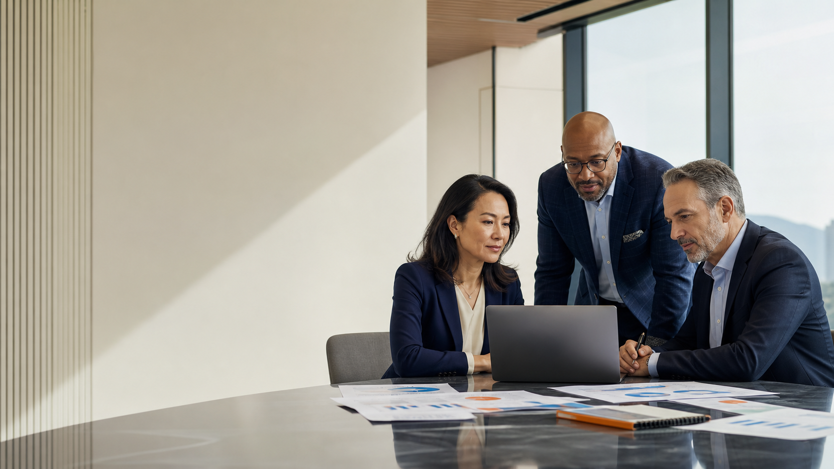 Healthcare executives reviewing value-based contract performance on a laptop